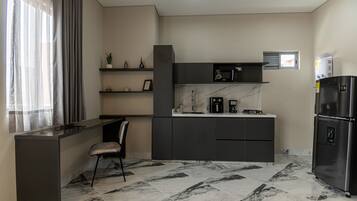Una cocina moderna con una isla integrada, un refrigerador, un microondas y una cafetera.