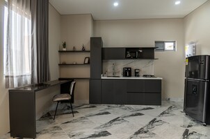 Una cocina moderna con una isla integrada, un refrigerador, un microondas y una cafetera.