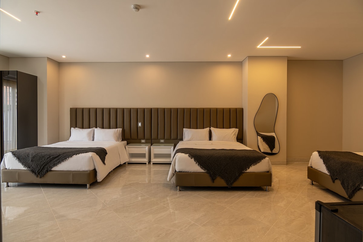Habitación familiar, varias camas, baño privado | Ropa de cama de alta calidad, edredón, minibar y escritorio