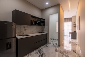 A modern kitchen with a built-in refrigerator, a sink, and a countertop. - Hotel Colores Estadio (Medellín)