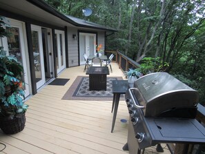 A deck with a grill, outdoor furniture, and a satellite dish.