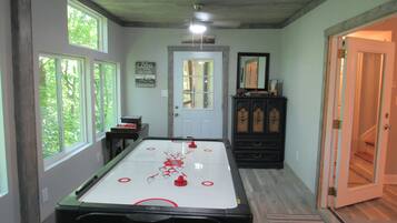 A room with a pool table, a door, and a window.