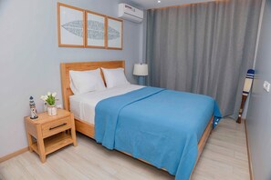 Habitación de hotel ordenada con cama, mesita de noche, lámpara y un adorno.