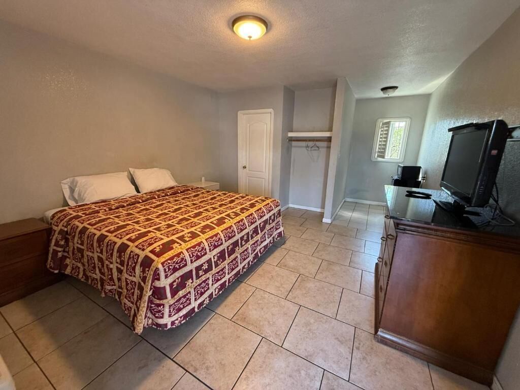 A bedroom with a bed, a television, and a wardrobe.