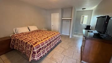 A bedroom with a bed, a television, and a wardrobe.