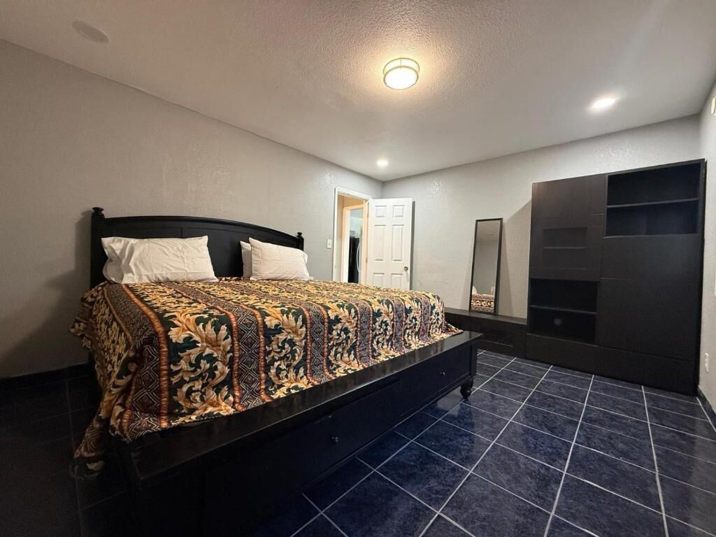 A bedroom with a bed, a wardrobe, and a door.