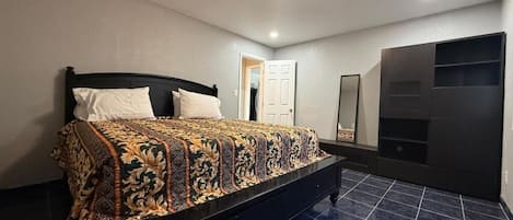 Un dormitorio con cama, armario y puerta.