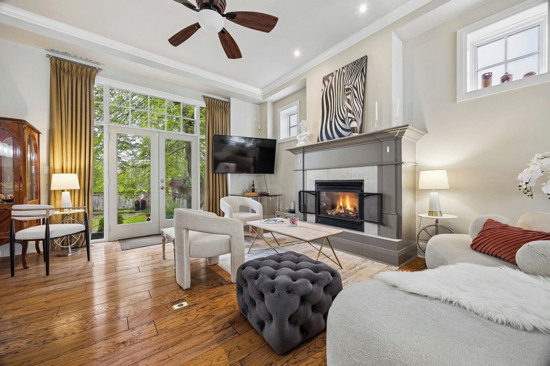 Una sala de estar con chimenea, televisor y vistas al exterior.