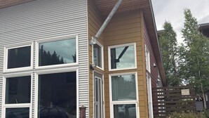 Un edificio de dos pisos con ventanas grandes y una chimenea.