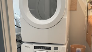 Una lavadora y secadora apiladas en un cuarto de lavandería.