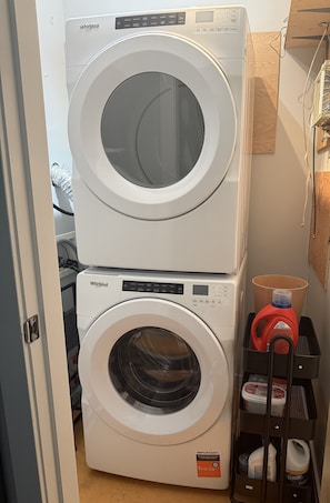 A stacked washer and dryer unit in a laundry room. - Welcome to The Hanson Hideaway located in the heart of downtown Whitehorse. (Whitehorse)