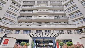 A multi-story hotel with a central entrance, balconies on each floor, and a sign indicating it is a residence de tourisme. - Modern Studio - 2P - Issy-les-moulineaux / Javel (La Courneuve)