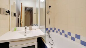 A bathroom with a white sink, mirror, and a shower with a handheld showerhead. - Modern Studio - 2P - Issy-les-moulineaux / Javel (La Courneuve)