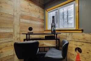 A room with wooden walls, a window with a frosted glass view, a table with a bottle, a clock, and two chairs. - Cozy 3BR w/Jacuzzi, Fireplace, Games near Kalahari (Pocono Summit)