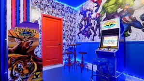 A room with arcade games, a red door, and a wall with superhero posters. - Elegant Villa in ChampionsGate | Near Disney (Davenport)