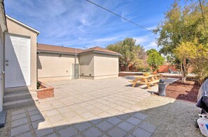 A residential backyard with a paved patio, a wooden table, and a barbecue grill. - Walk 2 Sofi/Intuit/Forum Spacious 4bd/2ba Beautiful Inglewood Home (Inglewood)