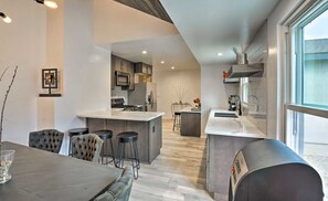 A modern kitchen with a central island, bar stools, and a dining area with a table and chairs. - Walk 2 Sofi/Intuit/Forum Spacious 4bd/2ba Beautiful Inglewood Home (Inglewood)