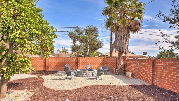 A backyard with a brick wall, a patio table with chairs, and a fire pit. - Walk 2 Sofi/Intuit/Forum Spacious 4bd/2ba Beautiful Inglewood Home (Inglewood)