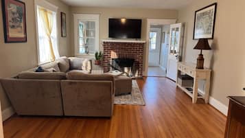 Una sala de estar con sofá, chimenea y televisor.