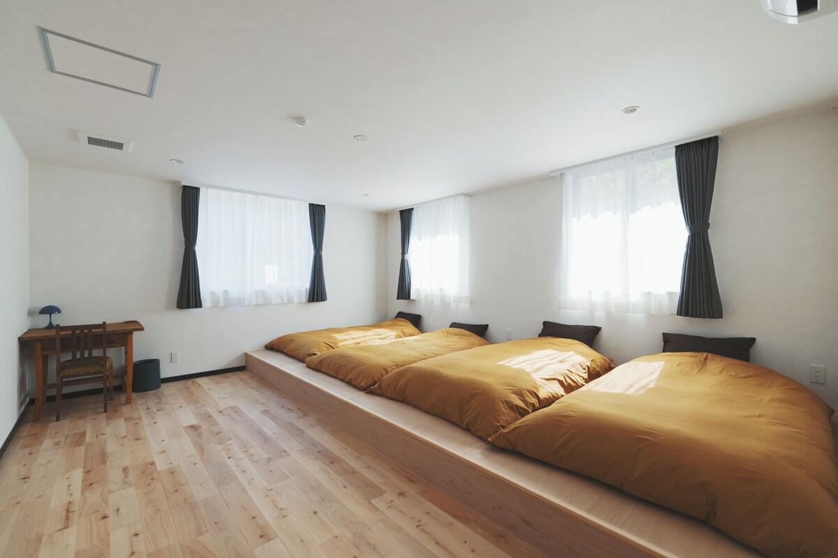 Une chambre avec deux lits, un bureau et une chaise.