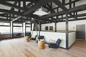 An interior space with exposed beams, a reception desk, and seating areas. - kadoya (Kosuge)