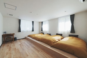 A room with two beds, a desk, and a chair.