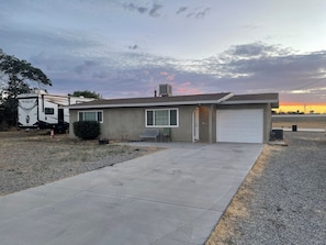 A single-story house with a garage, a driveway, and a parked recreational vehicle. - The High Desert Hideout - Enjoyable 2-bedroom, 1 bath
Spacious yard, RV parking. (Hesperia)