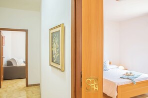 Een hotelkamer met een bed, nachtkastje en een aan de muur hangend schilderij.