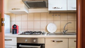 Une cuisine moderne équipée d’une cuisinière à gaz, d’une machine à café et d’un évier.