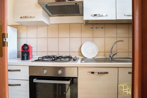 Eine moderne Küche mit einem Gasherd, einer Kaffeemaschine und einem Spülbecken.