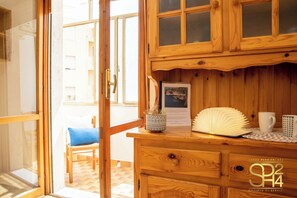 Ein Holzkabinet mit Glastür, ein gerahmtes Bild, ein dekorativer Fächer und eine Tasse auf einem Tisch.