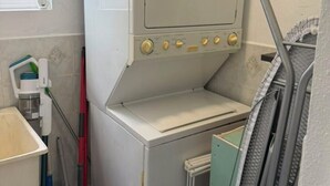 A compact laundry room with a washing machine, a drying rack, and a mop. - Cap Estate 3BR Townhome, Private Plunge Pool, Golf (Gros Islet)