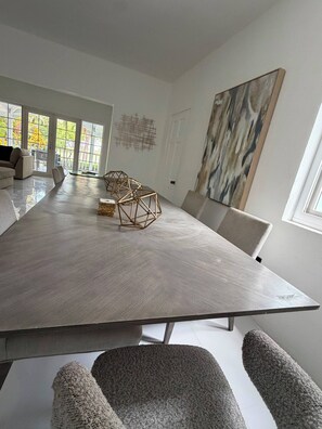 A modern dining room with a large table, chairs, and a view through the glass doors. - Cap Estate 3BR Townhome, Private Plunge Pool, Golf (Gros Islet)