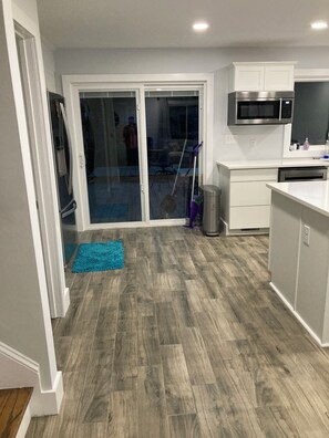 A modern kitchen with a microwave, oven, and a sliding glass door leading to a patio. - 3-bedroom house in terrific Gastonia with cool AC breeze. (Gastonia)