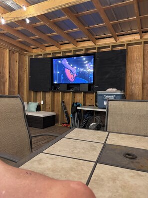 A room with a television mounted on the wall, a Coleman cooler, and a fan. - 3-bedroom house in terrific Gastonia with cool AC breeze. (Gastonia)