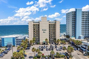 A hotel with a view of the ocean, a parking lot, and a beach in the background. - Horizon East Cabana 4 - Oceanfront in Garden City Beach (Garden City Beach)