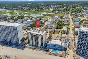 A high-rise hotel with multiple floors, a pool area, and a beach view. - Horizon East Cabana 4 - Oceanfront in Garden City Beach (Garden City Beach)