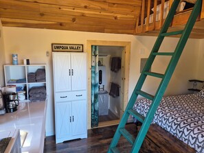 A bedroom with a bunk bed, a white wardrobe, a teal ladder, and a sign reading 'UMPQUA VALLEY'.