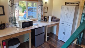 Cocina compacta con microondas, cafetera y un armario con la etiqueta 'UMPQUA VALLEY'.