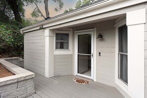 A house with a covered porch, a sliding glass door, and a small window. - Double Bogey by Sandpiper | Near Beach (Seabrook Island)