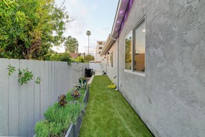 A residential property with a narrow front yard, a wooden fence, and a small garden bed with various plants. - Luxury 2BR Guesthouse Near SDSU & Mission Trails (San Diego)