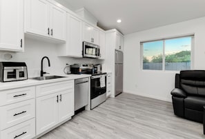A modern kitchen with white cabinetry, a stainless steel range, and a dishwasher. - Luxury 2BR Guesthouse Near SDSU & Mission Trails (San Diego)