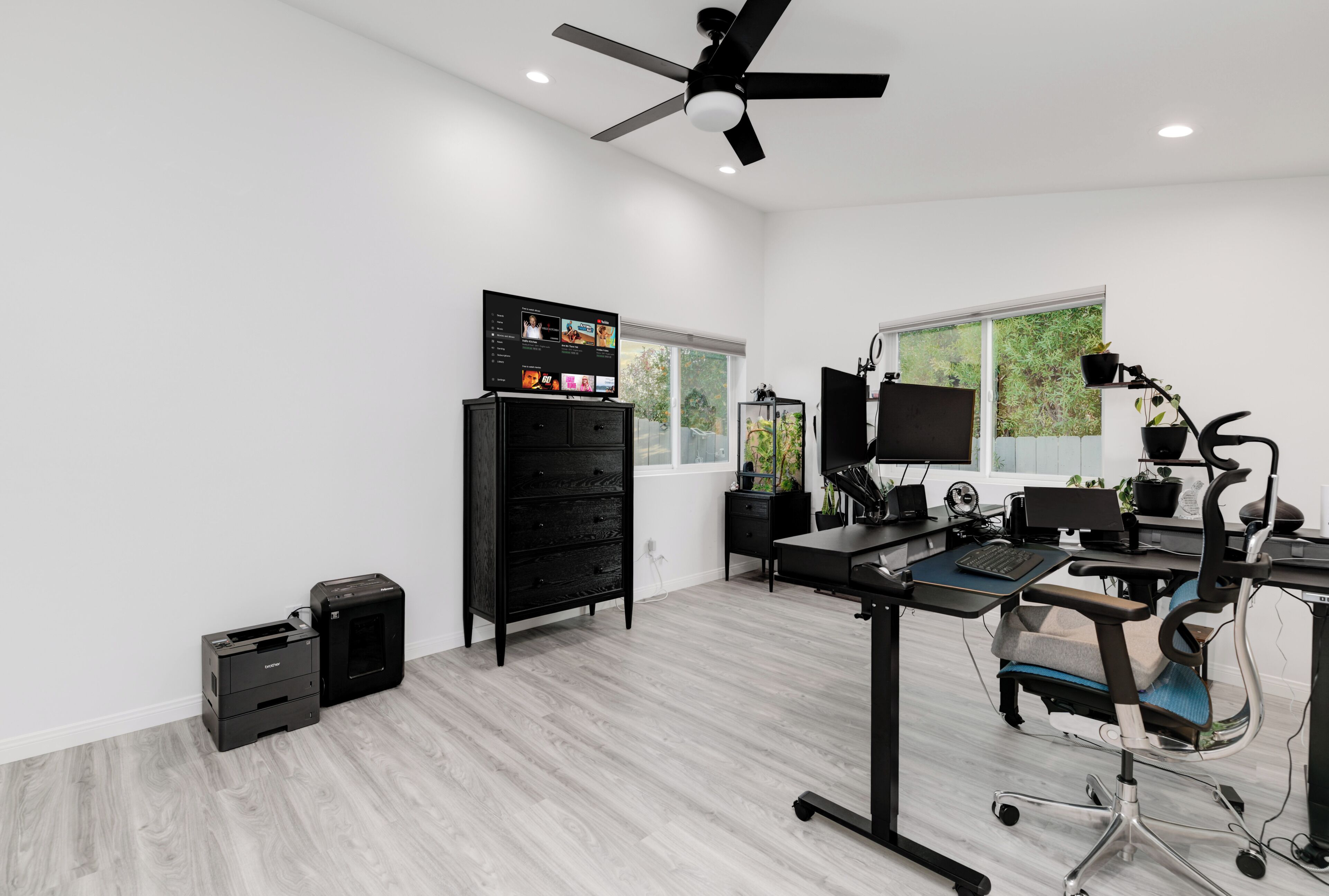 A modern office space with a desk, computer, monitor, and ergonomic chair.