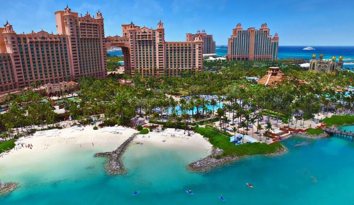 Ein Resort mit mehreren Hochhäusern, einem Strand und einem Poolbereich.