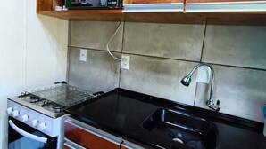 Una cocina con gabinetes de madera, un microondas, una estufa y un lavaplatos.