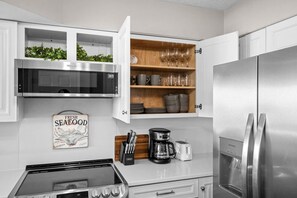 Eine moderne Küche mit einem Edelstahl-Kühlschrank, einer Mikrowelle und einem Gasherd.