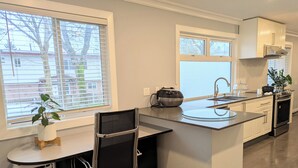 Een moderne keuken met een centraal eiland, een inbouwspoelbak en een fornuis.