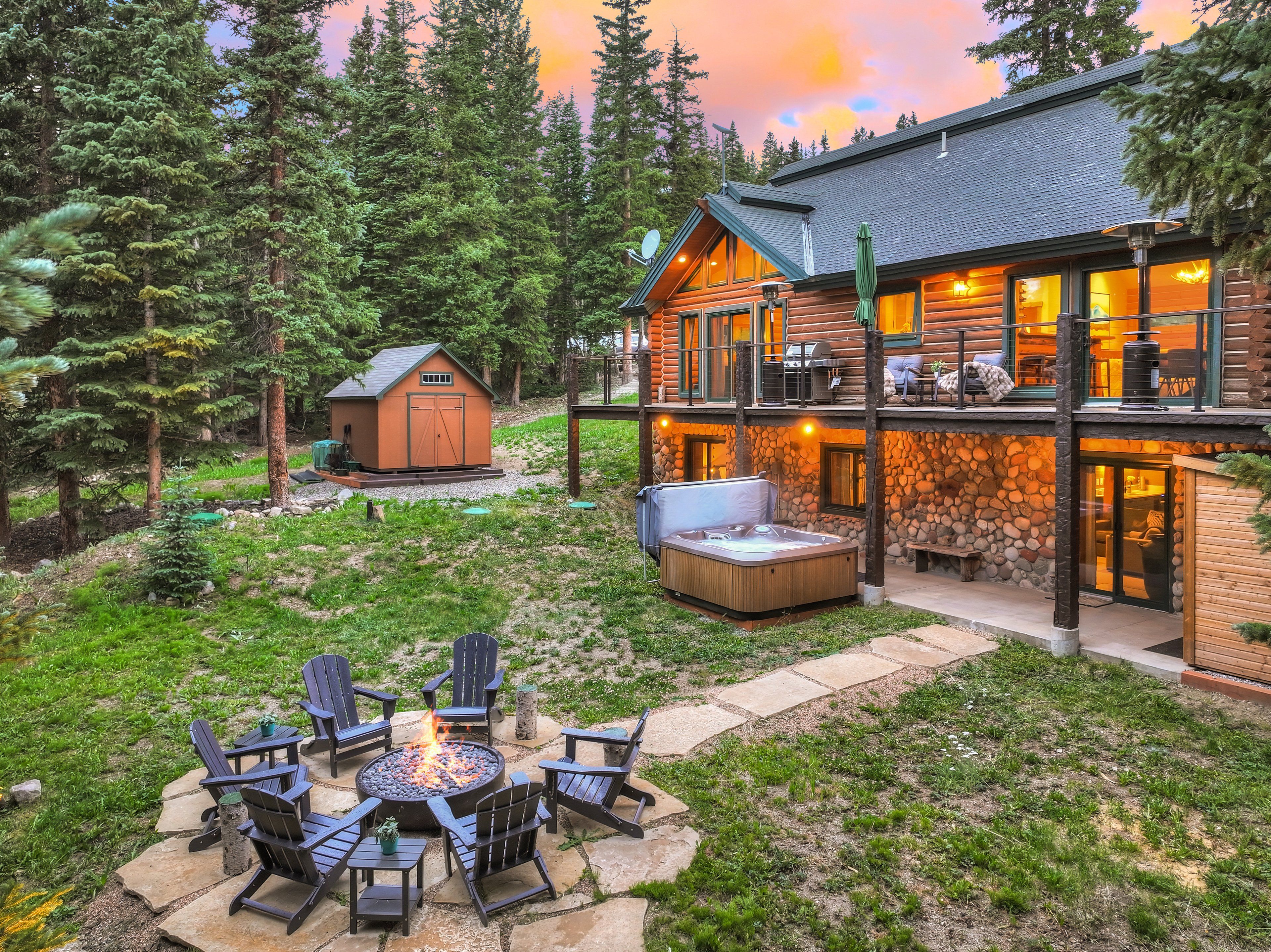 A log cabin with a hot tub and outdoor seating area.