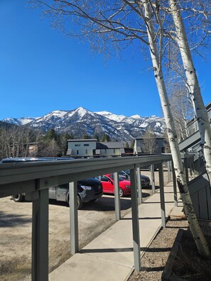 A parking area with vehicles, a building, and a mountain range in the background. - 2BR/2B Condo with Hot Tub/Pool access. 4.5 Miles to Jackson Hole Mountain Resort (Wilson)
