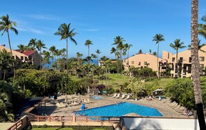 A resort with a swimming pool, palm trees, and a view of the ocean. - South Kihei Luxury Condo • Gorgeous Sunset Views. Steps to Kamaole Beach III (Kihei)